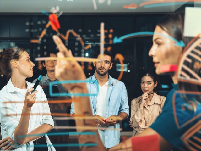 Group of smart diverse businesspeople brainstorming business strategy. Young female leader sharing, explaining, designing business idea at night office. Business planing, Working together. Tracery. SSUCv3H4sIAAAAAAAACnRTu27cMBDsA+QfDqpNhBQpPly6SBcgfZBiSa58hHXkQZQcBIb/PdTTDJB02tnh7OxDb58/XS6NhRxc83h5W6ISh2GY8zTCFFIsMH3Y8RGjx7FGXkcuaQ1AqCP0YUpjgKEGLUzuGuGGBYzzMCzw+5ps8gTTnDEvXnbIwYTPRWMDT4nN8I8tvhyJNVlelFTzNOcQMecvX0OE6LB5qDh5tgvnO6b7gM2R2Er+R2/n/kPlW8gOhwEipjl/iG0fP8/JPGN0v9fOqo5HHBC2jvdmGsdVq3smCAK3RFgEYiQ1hGpHHci+ley00TDQVmrjCG0tJ6JDRUzfe6JUy8Box30PJ9kzxa1nPfGi7YlAw4hpQRHrJcfy1XGhTrKlzgprgKjOtkR4L4nxLRIpEUEqYNZ+2FAdgtbeEMOLXeEEEtOhJlRw2gnLuXVsncw2jubl14Tjrd4zzD6kasWvycGwEHg1LQh3GOGvd/cxuBCfKyRN1/VIDyWX5jiNy+Sb0++Q0h1sWefjpS9l8MCvkHOh+wOvarvyS6RbVSemad3brtr4cqlLyDiXrGs11bTlzDAmd8J23ddQdFY7h1CJ3UvwdVdhcdBoLa1XaIkzvCv7ouslWKIp9Z00YJGqMtX3PwAAAP//AwA74RY9xgMAAA==